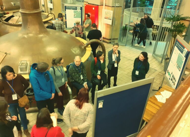 A group of people gathered around a copper still